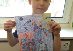 Chłopiec prezentuje rysuenk swojego Świata Wyobraźni